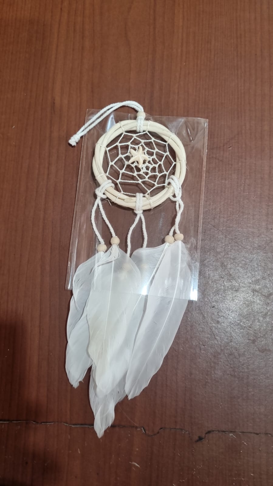 Small handmade rattan dreamcatcher 6 cm with white feathers, ideal for boho home or car decoration.