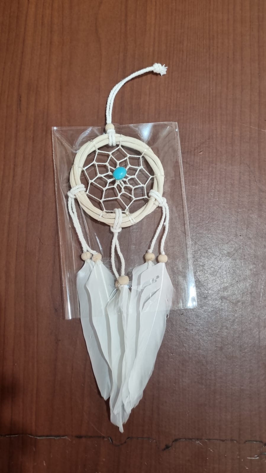 Small handmade rattan dreamcatcher 6 cm with white feathers, ideal for boho home or car decoration.