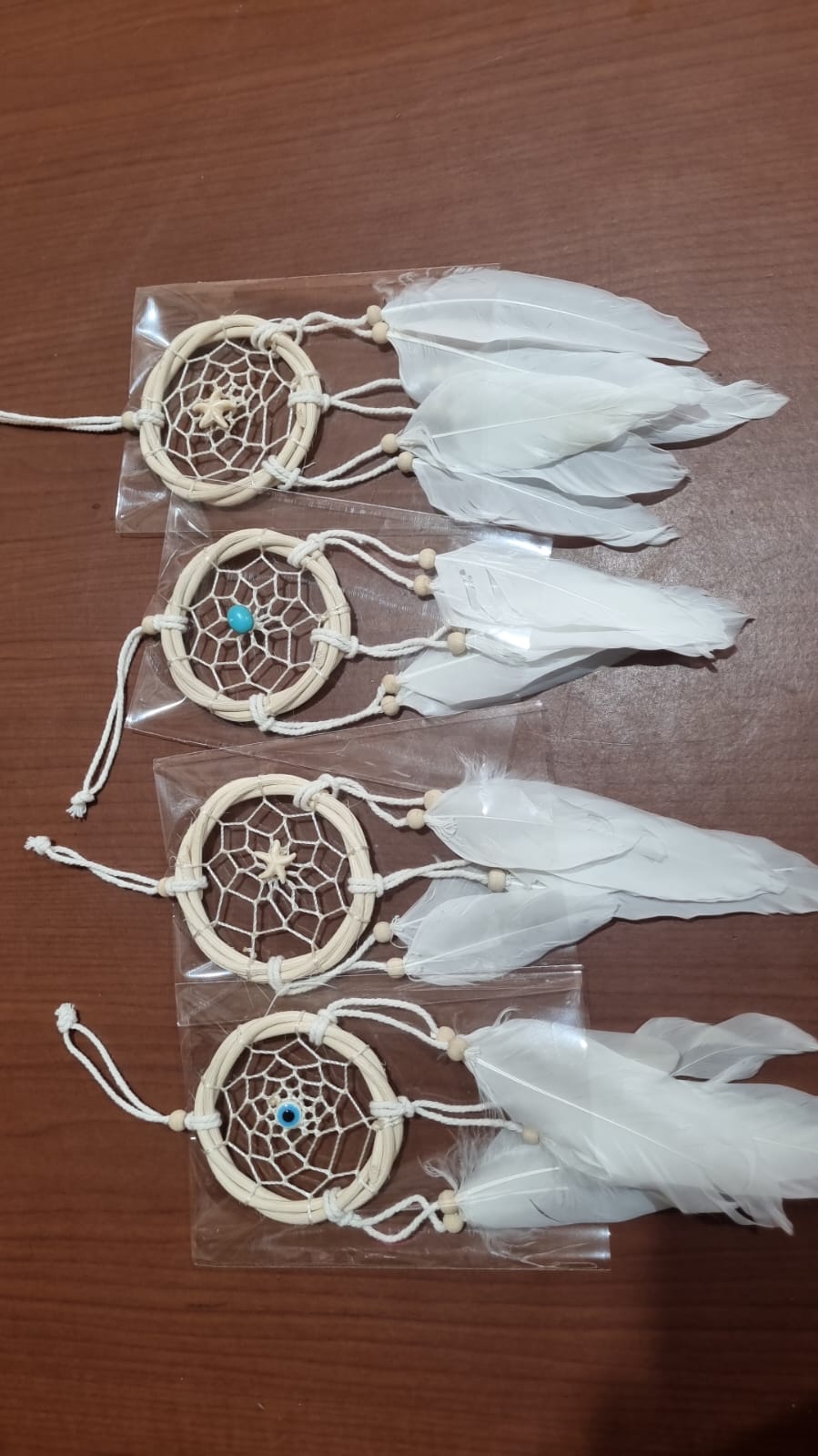 Small handmade rattan dreamcatcher 6 cm with white feathers, ideal for boho home or car decoration.