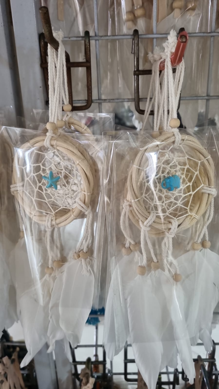 Small handmade rattan dreamcatcher 6 cm with white feathers, ideal for boho home or car decoration.