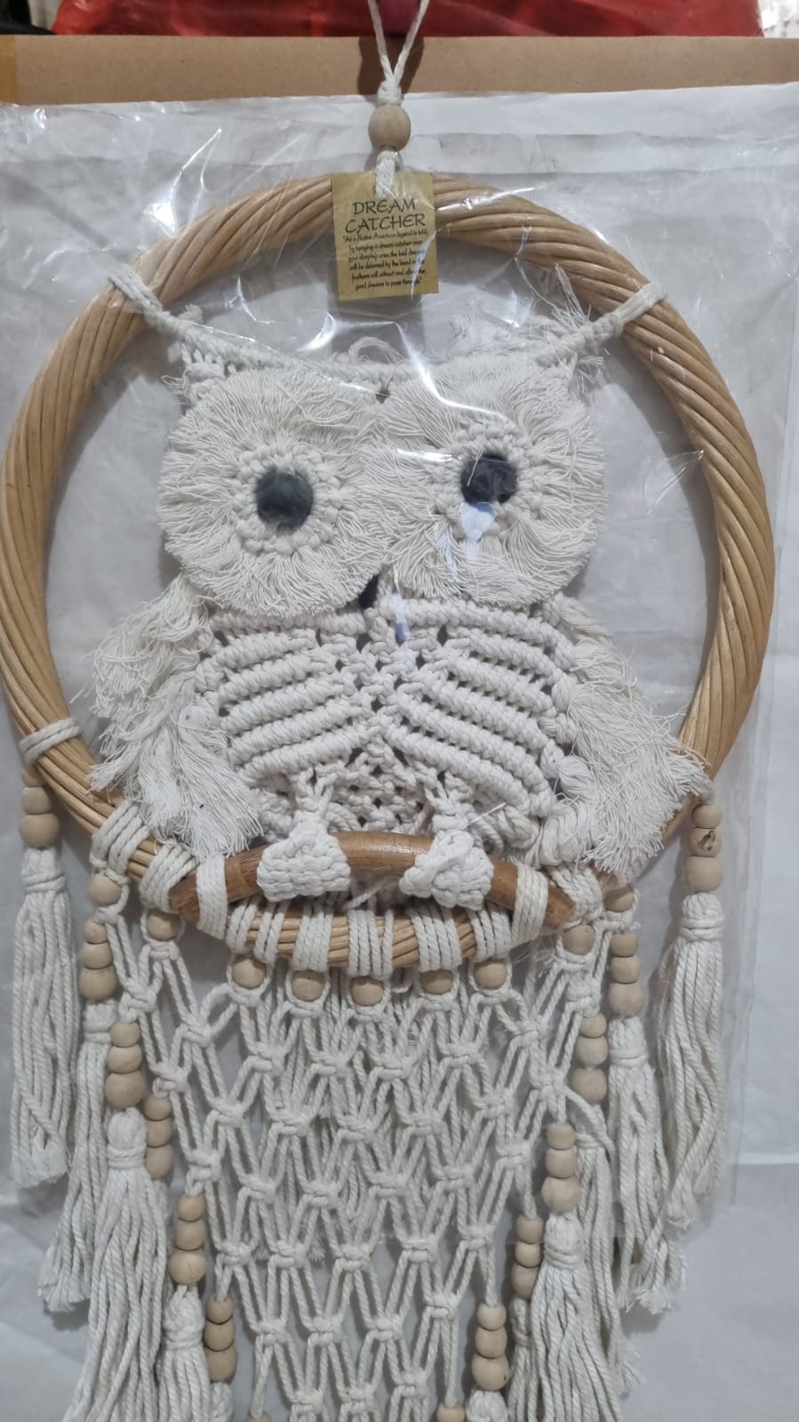 Handmade macrame dreamcatcher with soft fringe and rattan frame, in neutral tones for minimalist and rustic home decor.