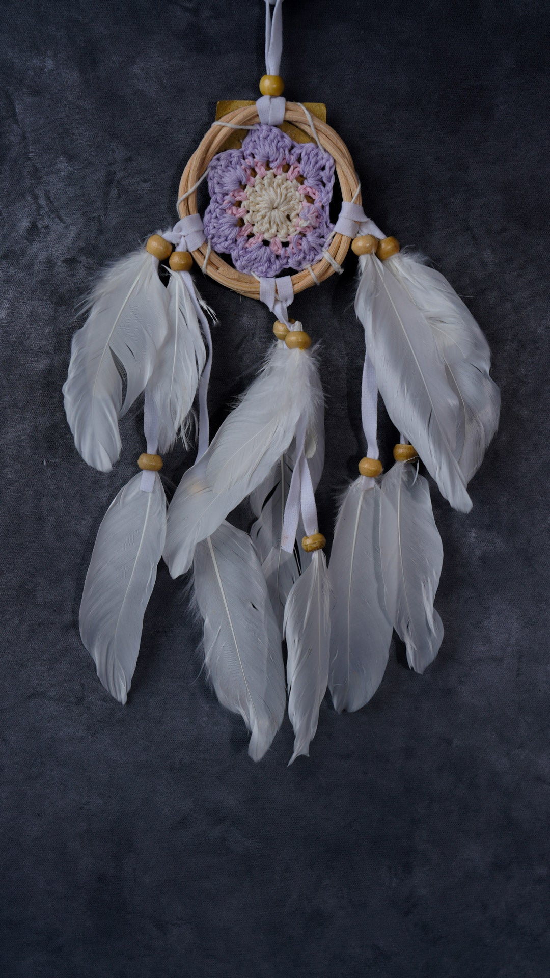 Hand-crocheted cotton mandala dream-catcher in rattan hoop with flowing white feathers and wood beads.
