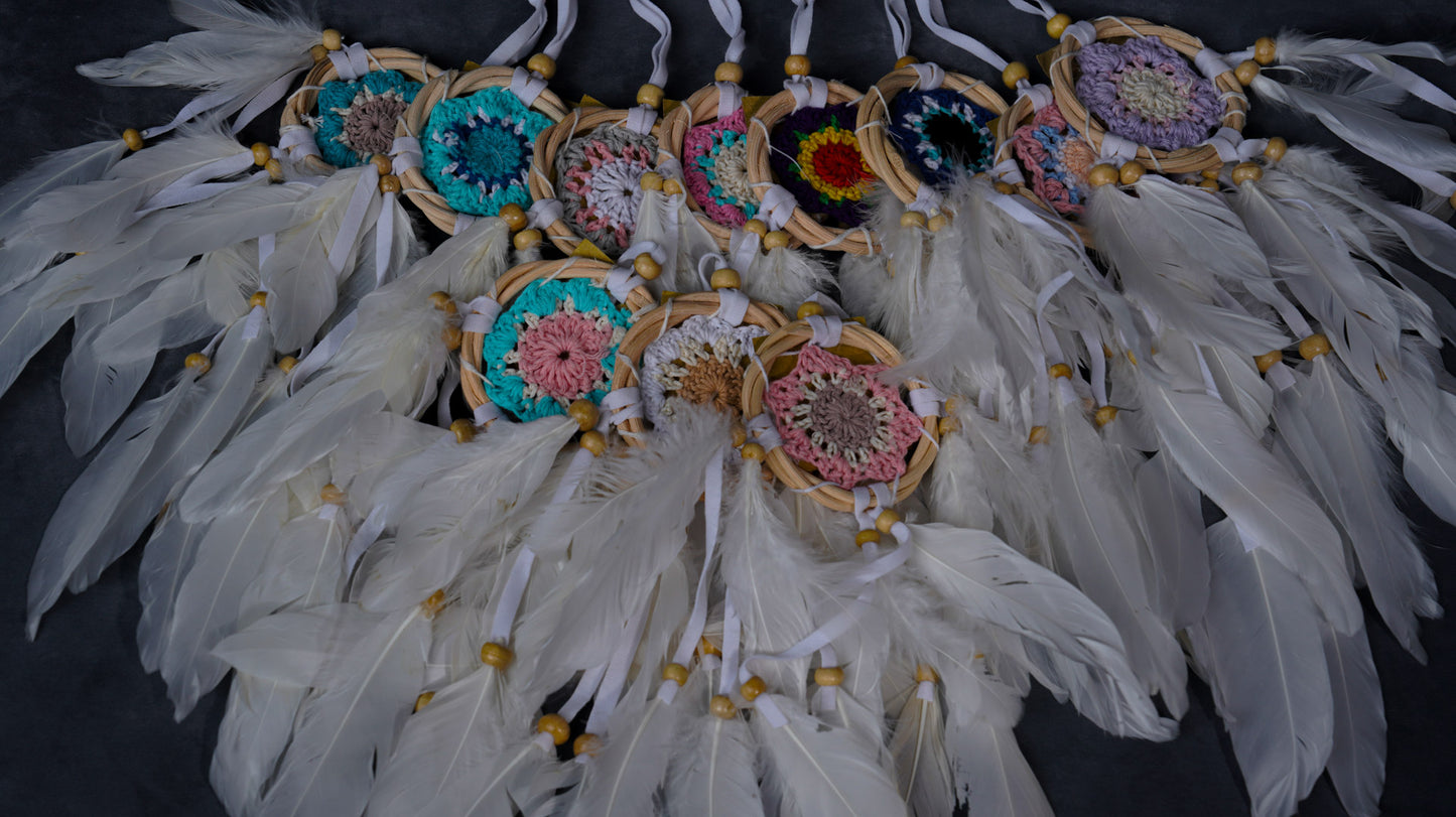 Hand-crocheted cotton mandala dream-catcher in rattan hoop with flowing white feathers and wood beads.