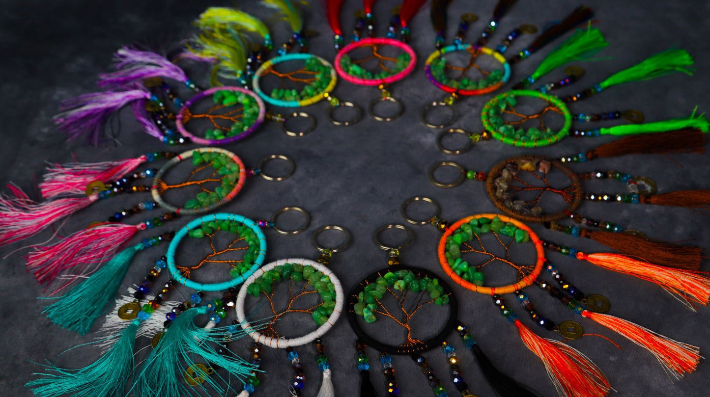 Turquoise-wrapped Tree of Life dreamcatcher keychain with green stone leaves and teal tassels.