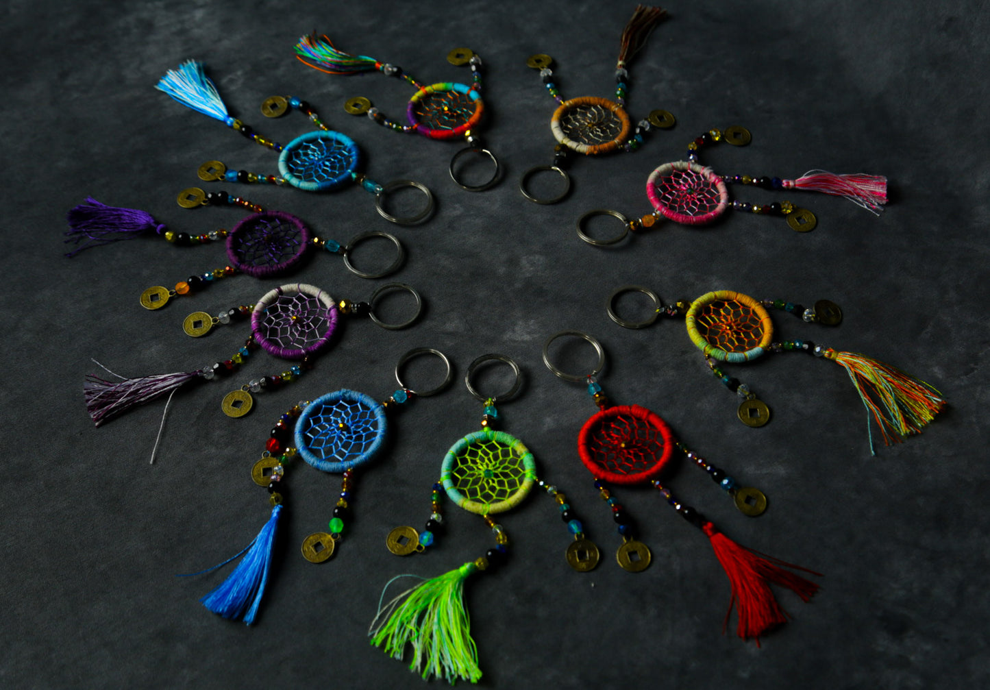 Hand-woven rainbow dreamcatcher keychain with tassel, beads, and lucky coins.