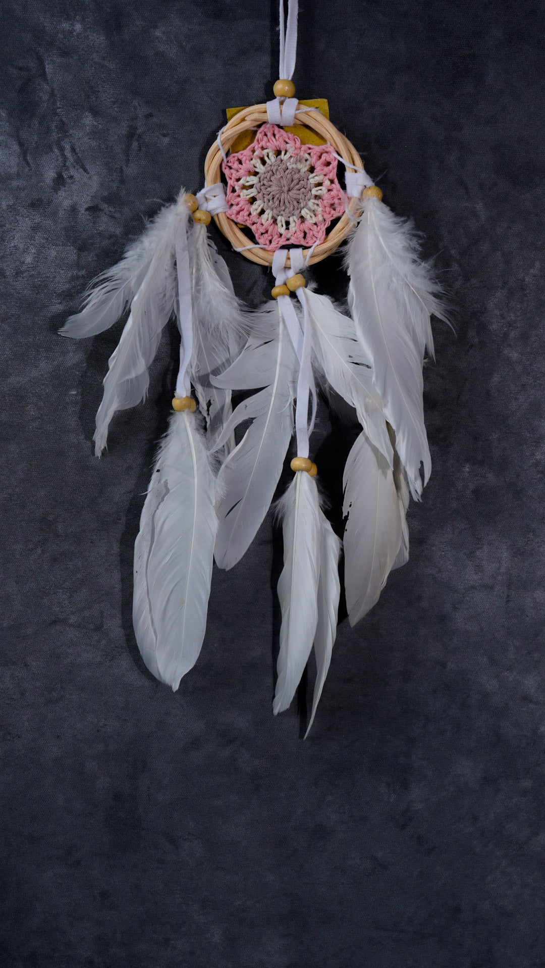 Hand-crocheted cotton mandala dream-catcher in rattan hoop with flowing white feathers and wood beads.