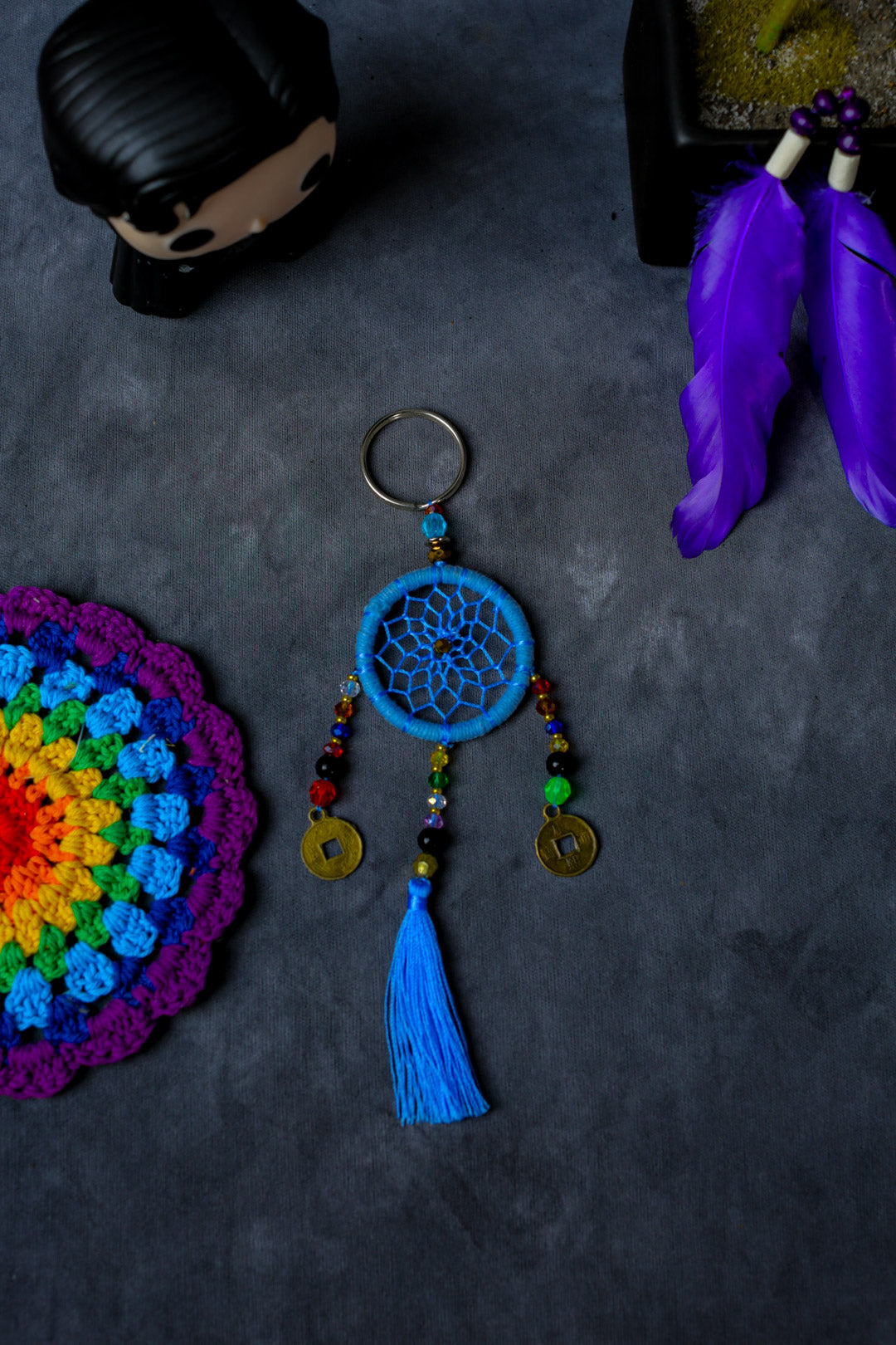 Hand-woven blue dreamcatcher keychain with tassel, beads, and lucky coins.