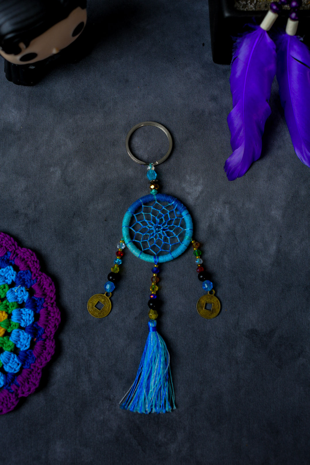Hand-woven light blue dreamcatcher keychain with tassel, beads, and lucky coins.