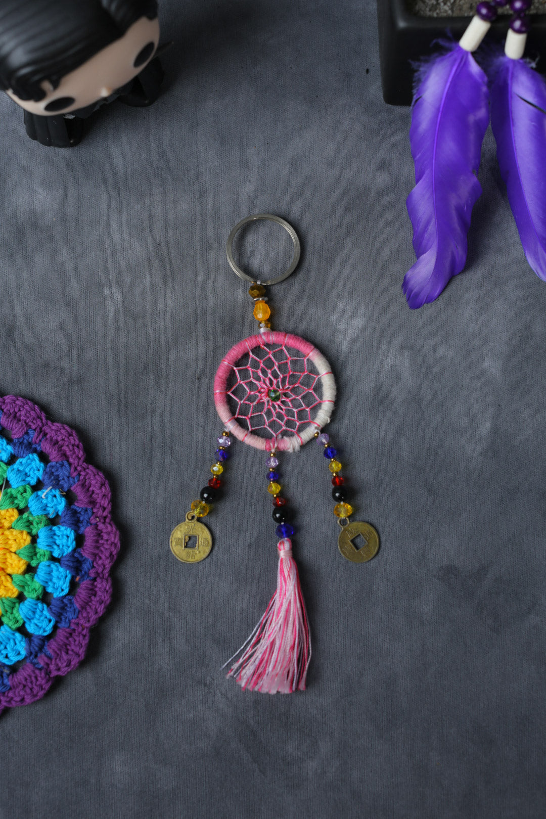 Hand-woven pink dreamcatcher keychain with tassel, beads, and lucky coins.