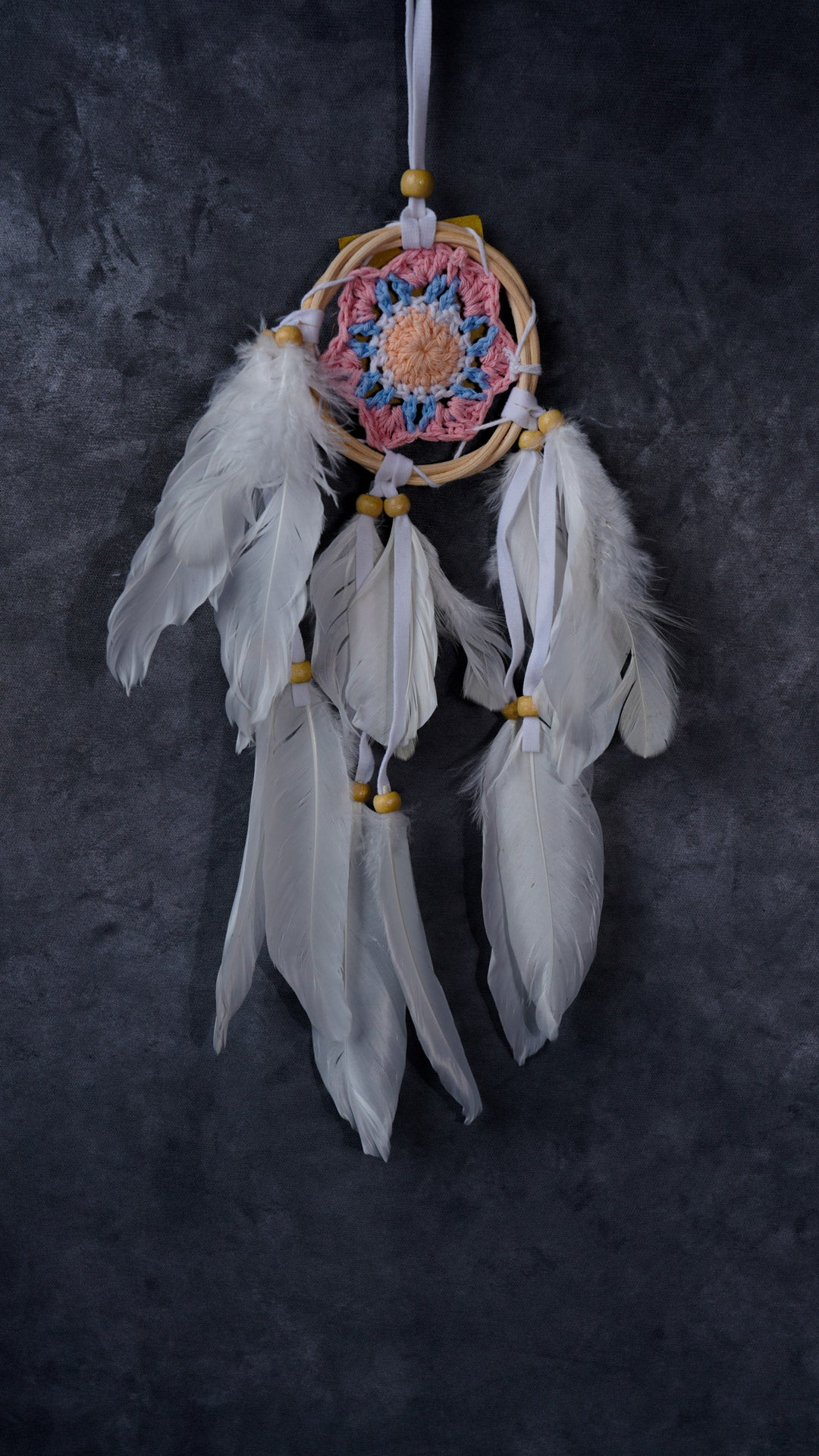 Hand-crocheted cotton mandala dream-catcher in rattan hoop with flowing white feathers and wood beads.