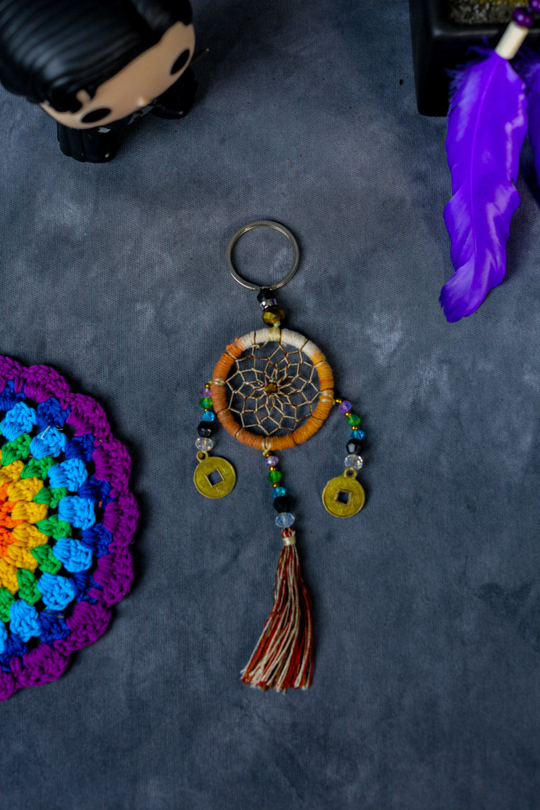 Hand-woven cream dreamcatcher keychain with tassel, beads, and lucky coins.