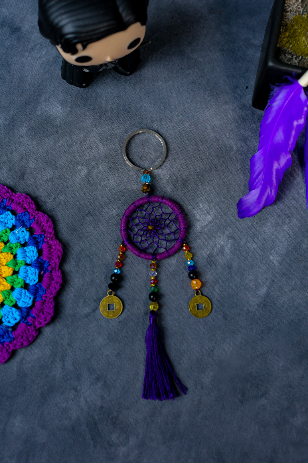 Hand-woven purple dreamcatcher keychain with tassel, beads, and lucky coins.