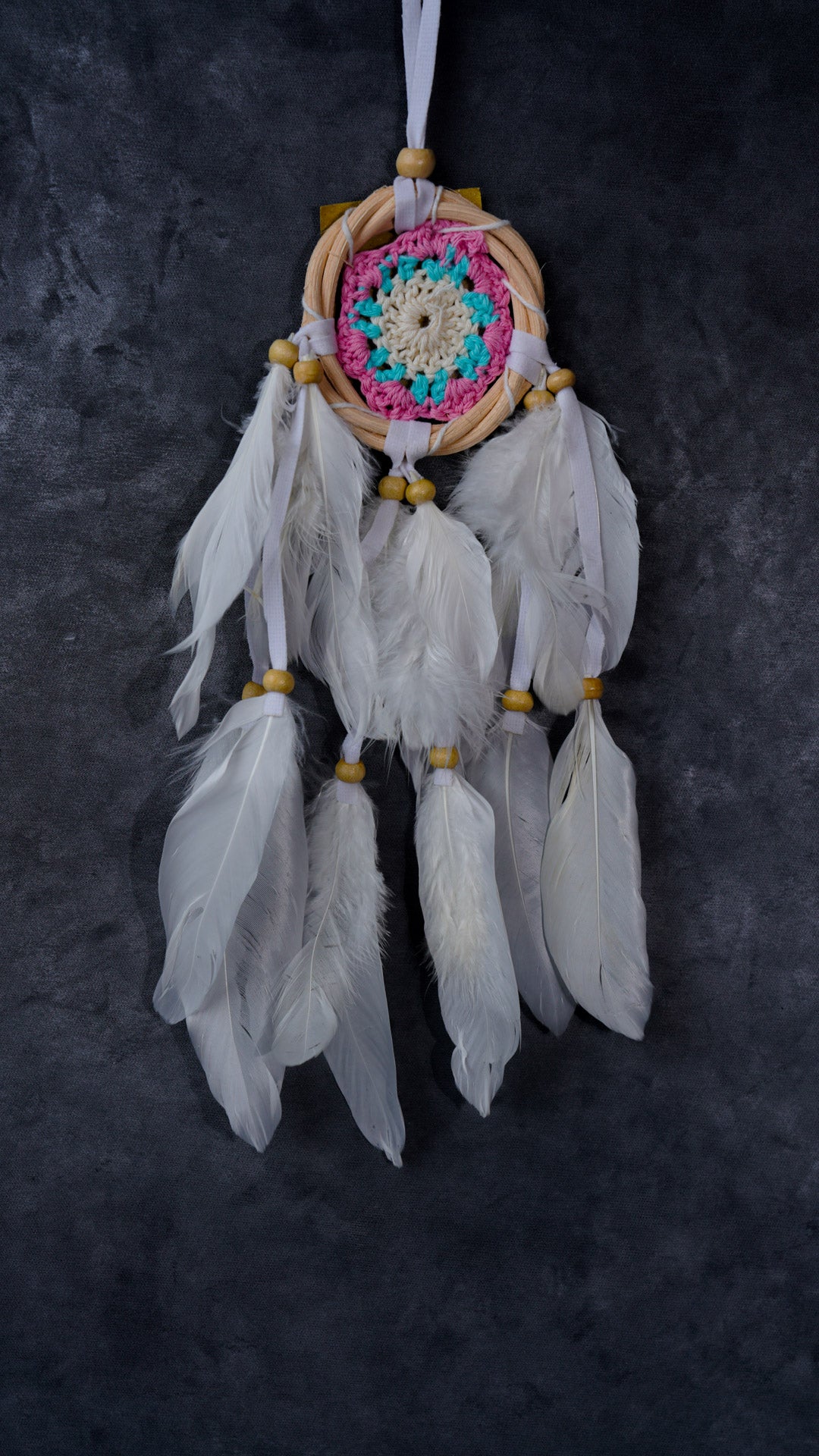 Hand-crocheted cotton mandala dream-catcher in rattan hoop with flowing white feathers and wood beads.