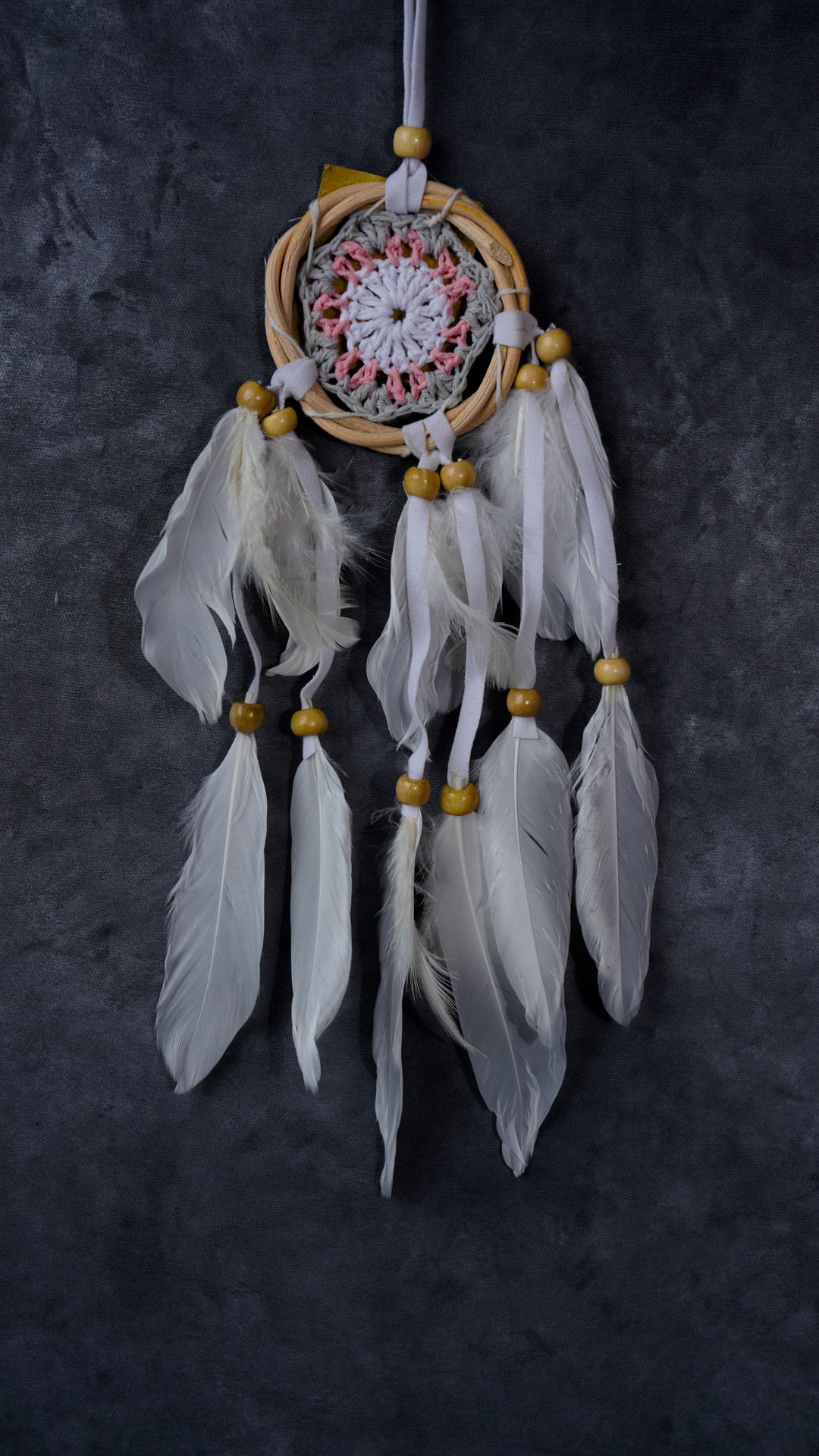 Hand-crocheted cotton mandala dream-catcher in rattan hoop with flowing white feathers and wood beads.