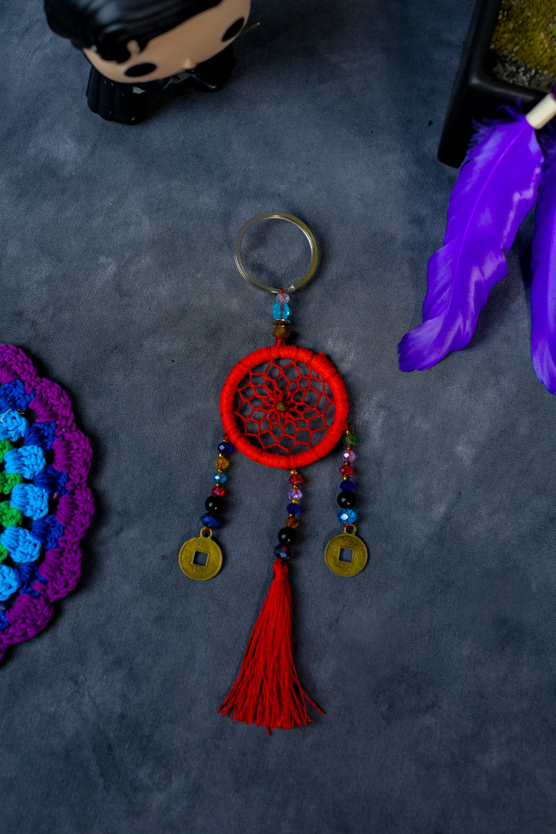 Hand-woven red dreamcatcher keychain with tassel, beads, and lucky coins.