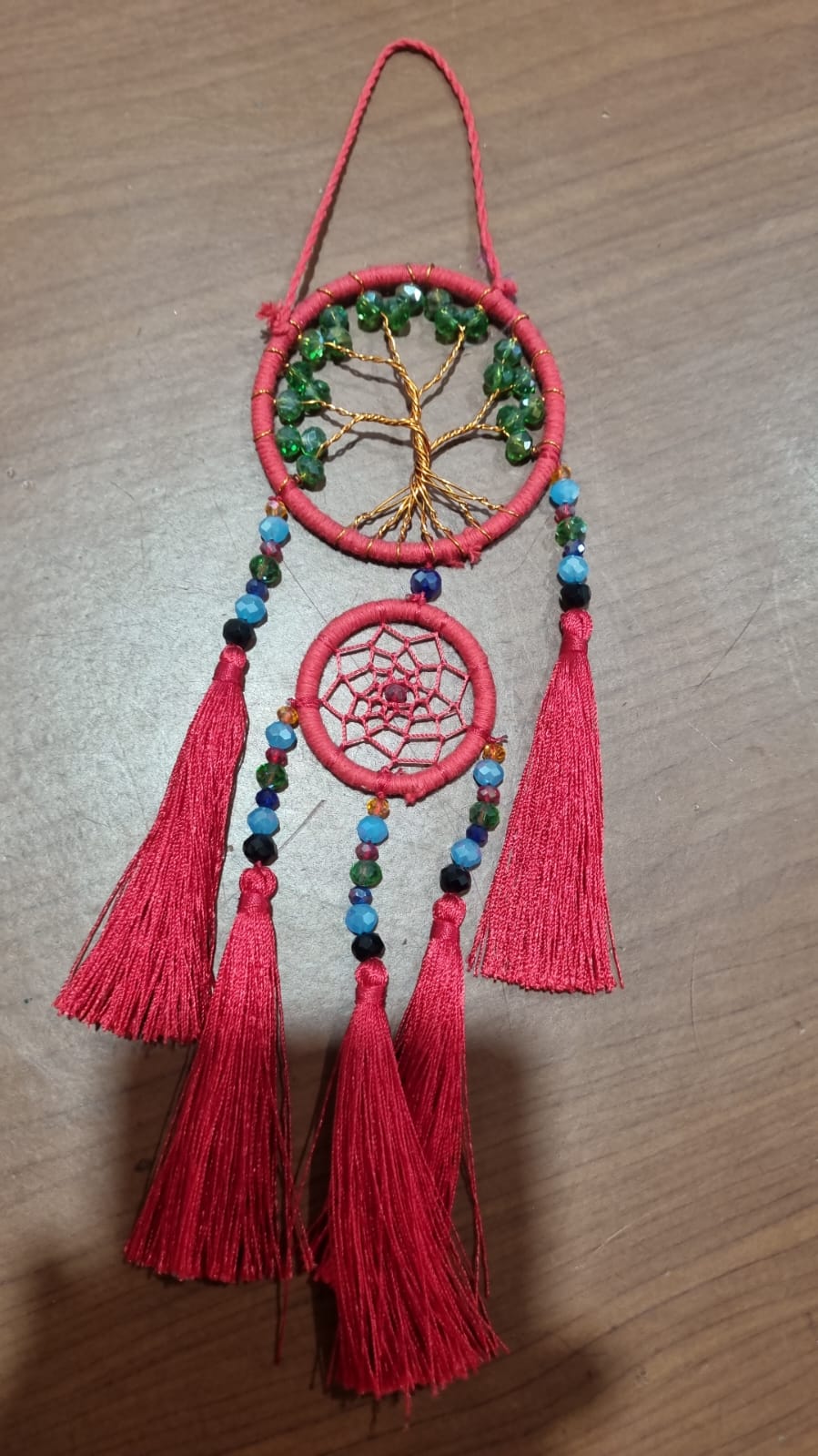 Artisan dreamcatcher with red tassels, tree of life wire design, and green crystal beads