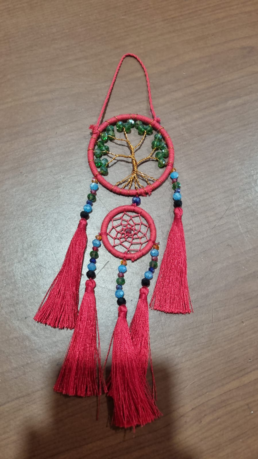 Artisan dreamcatcher with red tassels, tree of life wire design, and green crystal beads