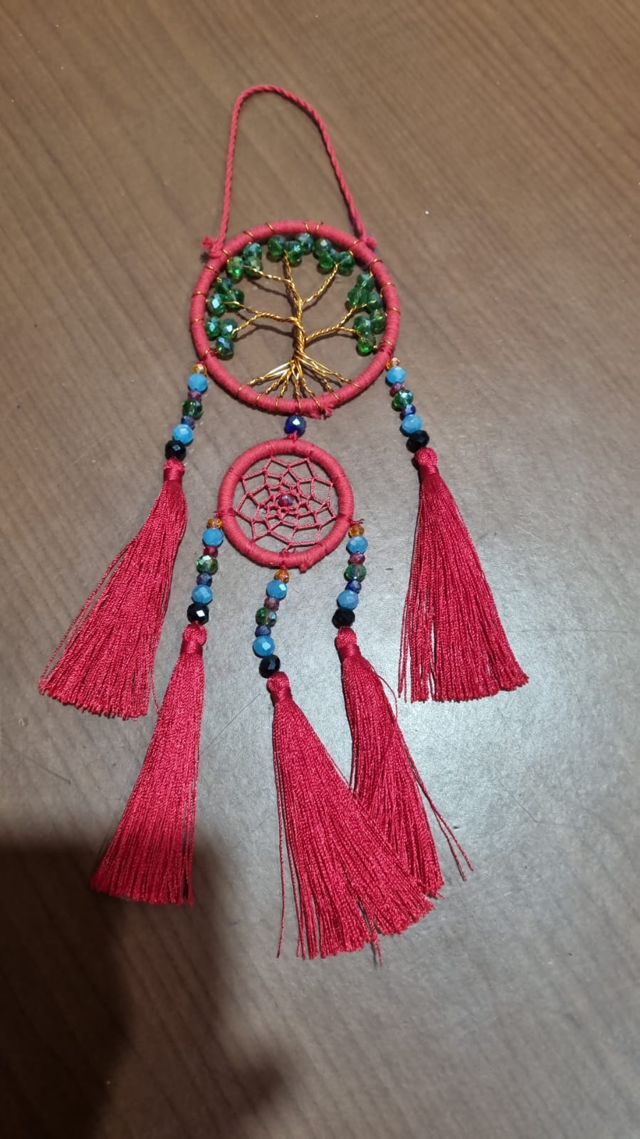 Artisan dreamcatcher with red tassels, tree of life wire design, and green crystal beads
