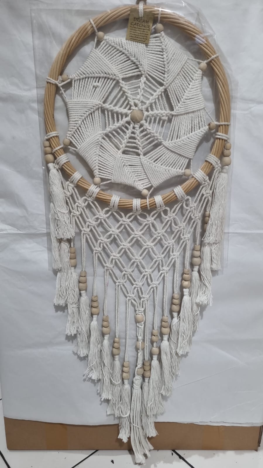 Rattan dreamcatcher with cotton spiral web and tassels, featuring wooden beads, perfect for boho wall décor or gifting.