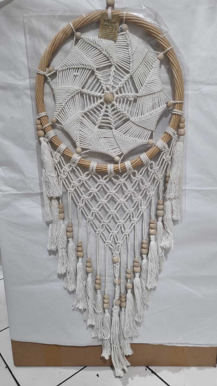 Rattan dreamcatcher with cotton spiral web and tassels, featuring wooden beads, perfect for boho wall décor or gifting.