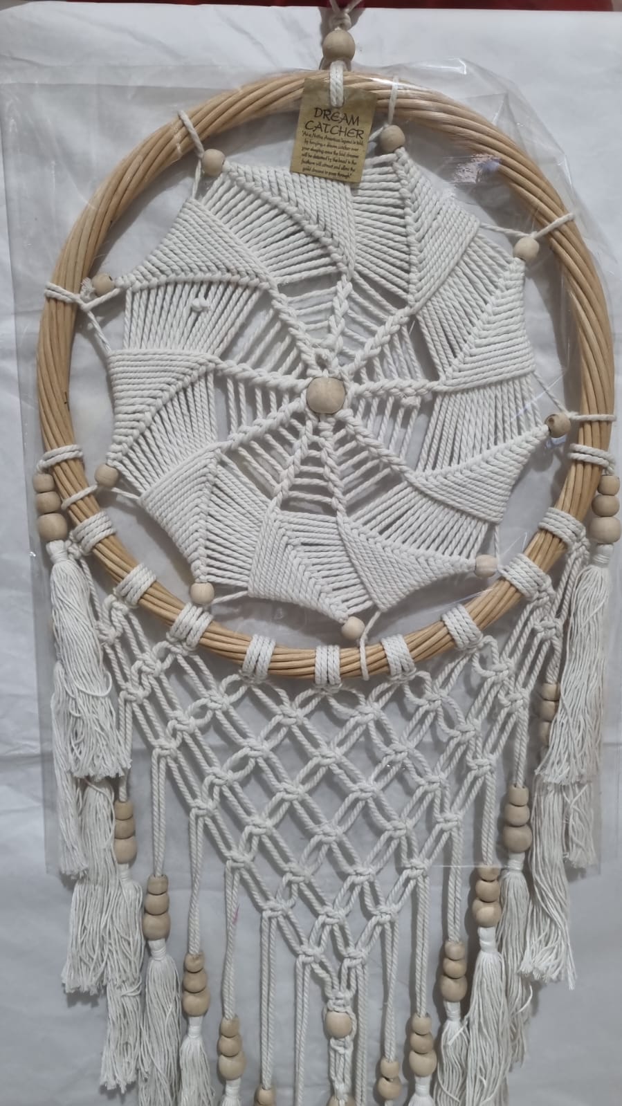 Rattan dreamcatcher with cotton spiral web and tassels, featuring wooden beads, perfect for boho wall décor or gifting.