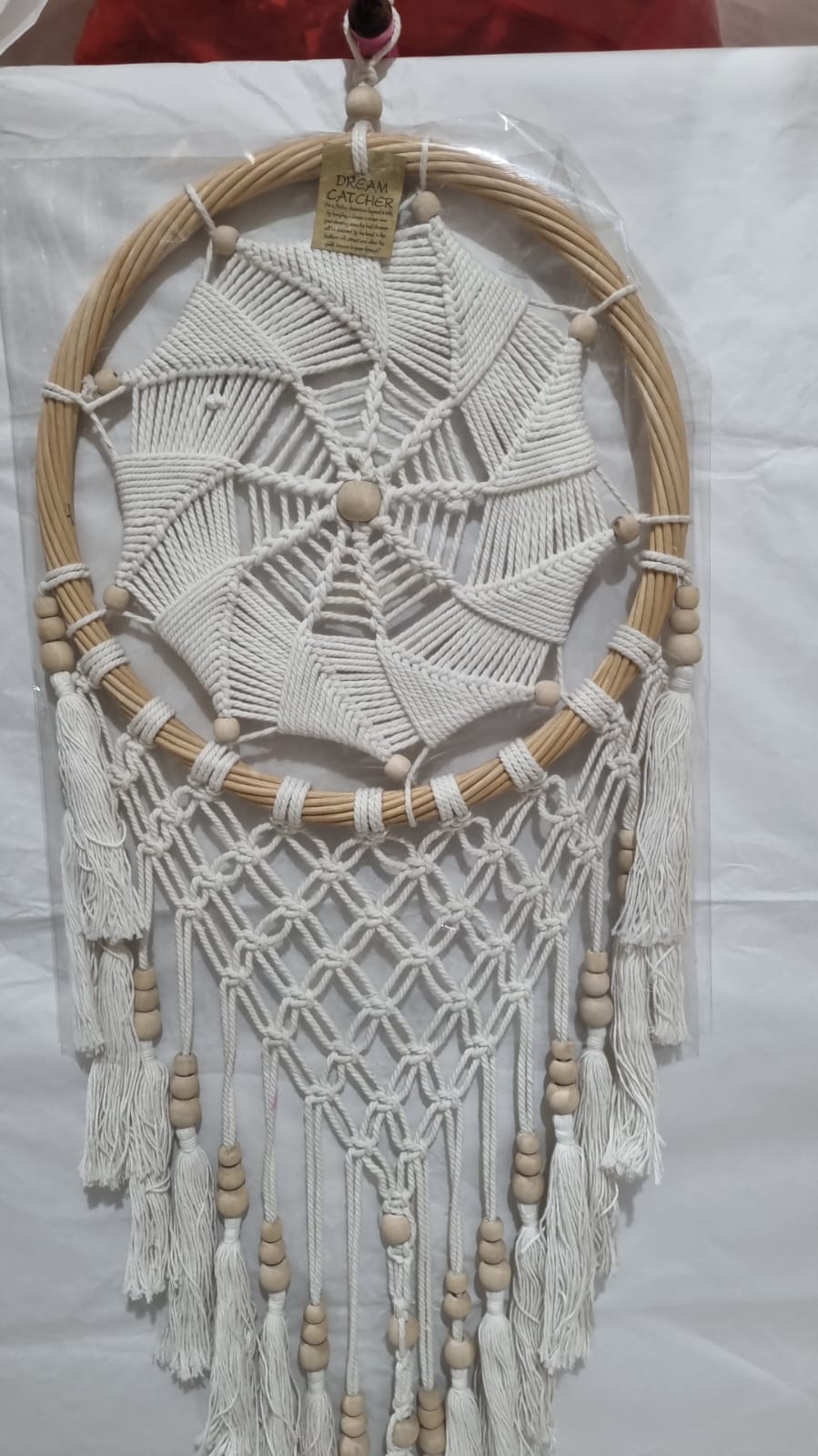 Rattan dreamcatcher with cotton spiral web and tassels, featuring wooden beads, perfect for boho wall décor or gifting.