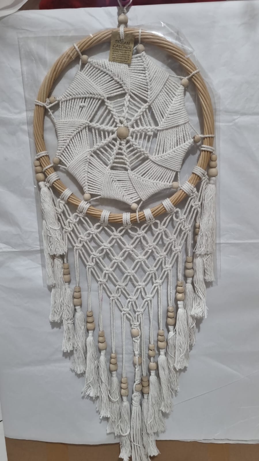 Rattan dreamcatcher with cotton spiral web and tassels, featuring wooden beads, perfect for boho wall décor or gifting.