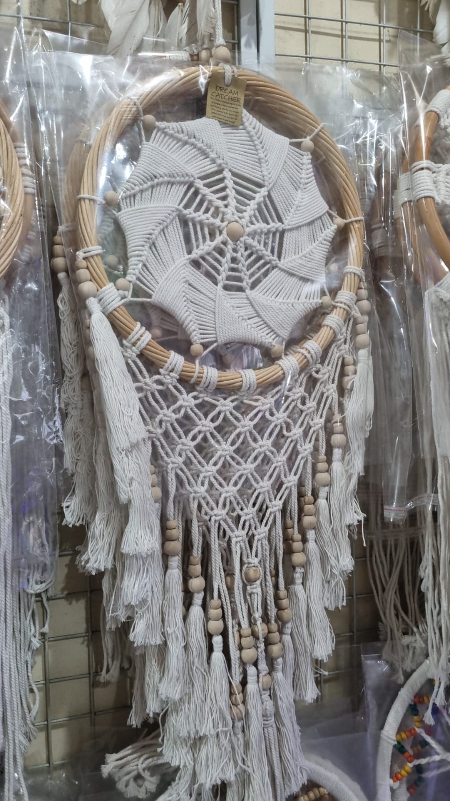 Rattan dreamcatcher with cotton spiral web and tassels, featuring wooden beads, perfect for boho wall décor or gifting.