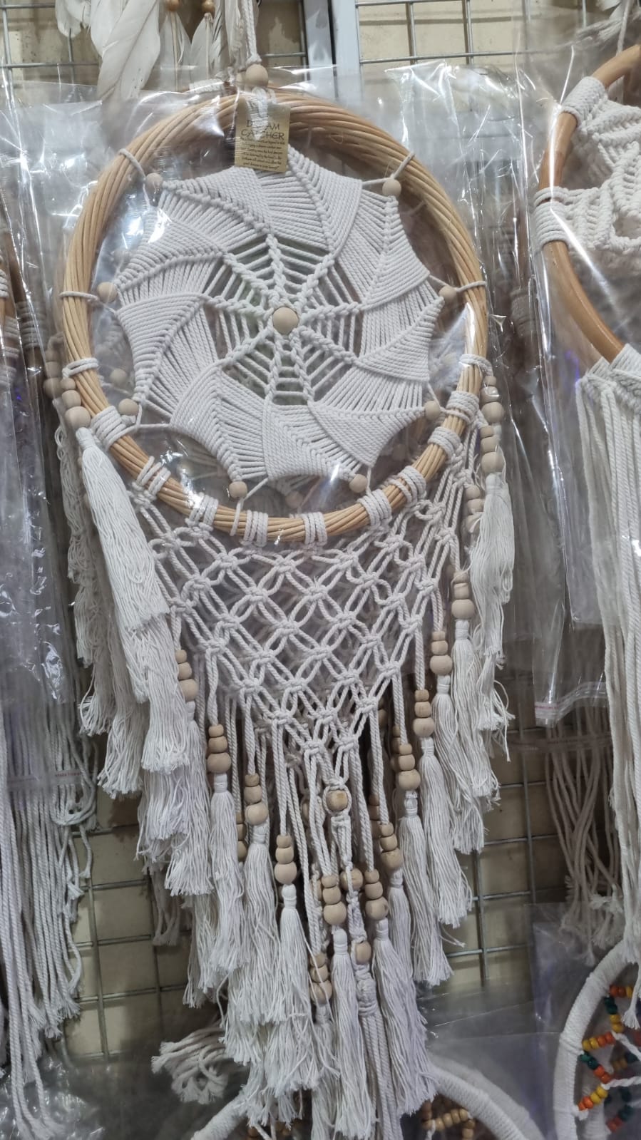 Rattan dreamcatcher with cotton spiral web and tassels, featuring wooden beads, perfect for boho wall décor or gifting.