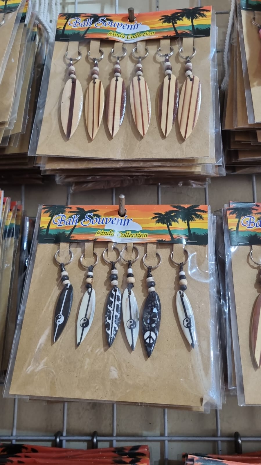 Resin surfboard keychain with shell accents, handmade souvenir keyring for bulk wholesale and surf shop gifts.