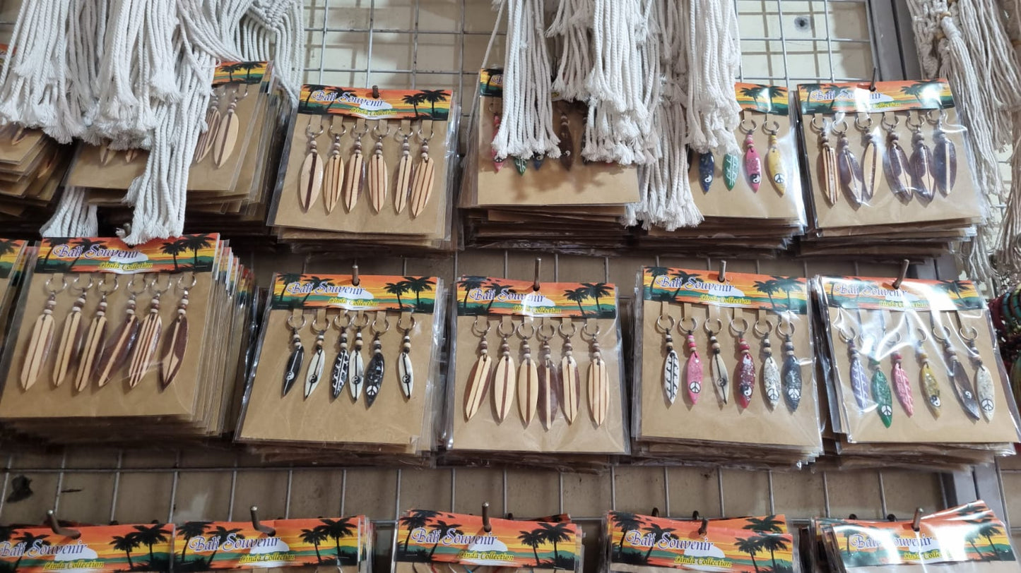 Resin surfboard keychain with shell accents, handmade souvenir keyring for bulk wholesale and surf shop gifts.