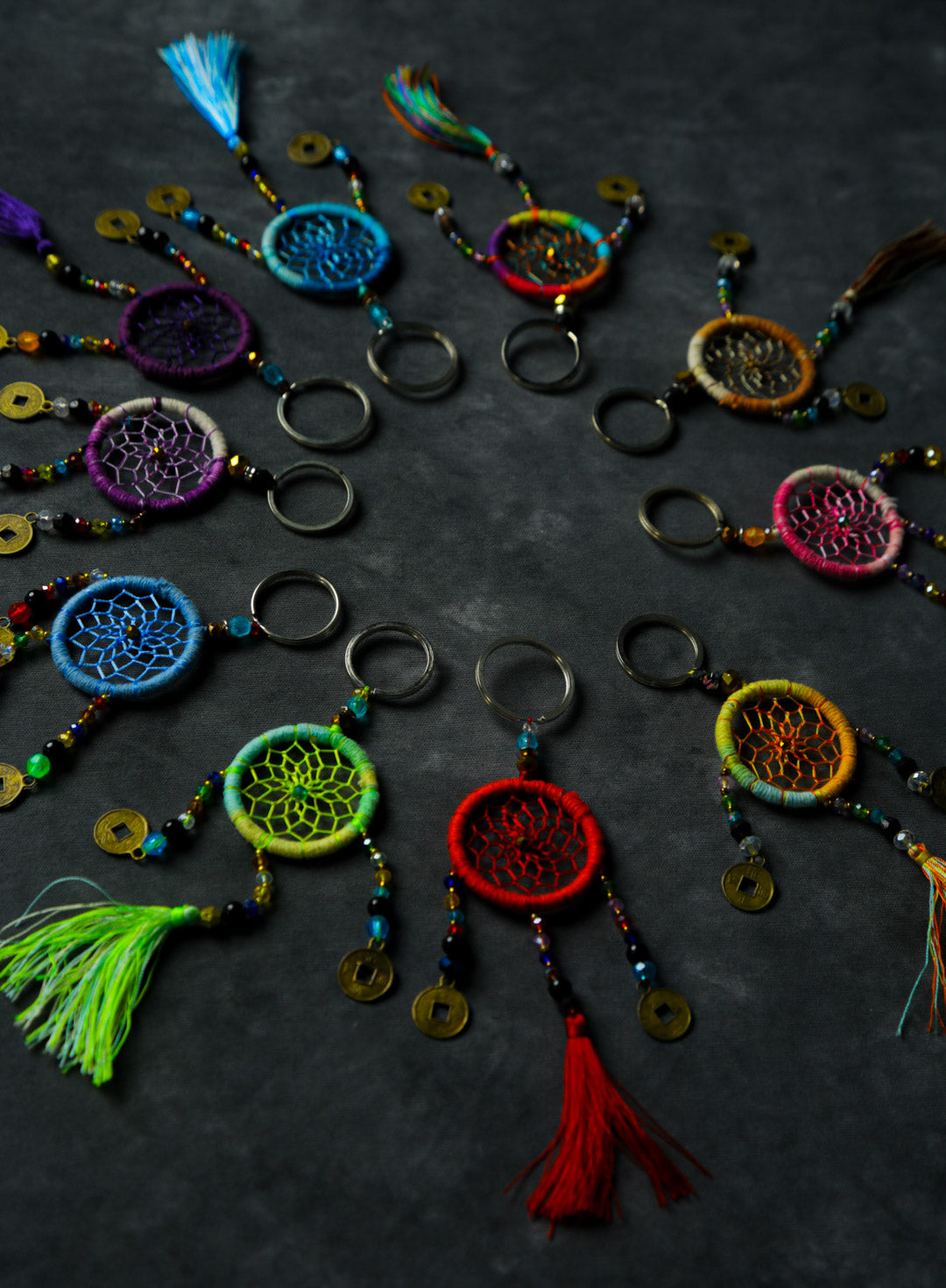 Hand-woven rainbow dreamcatcher keychain with tassel, beads, and lucky coins.