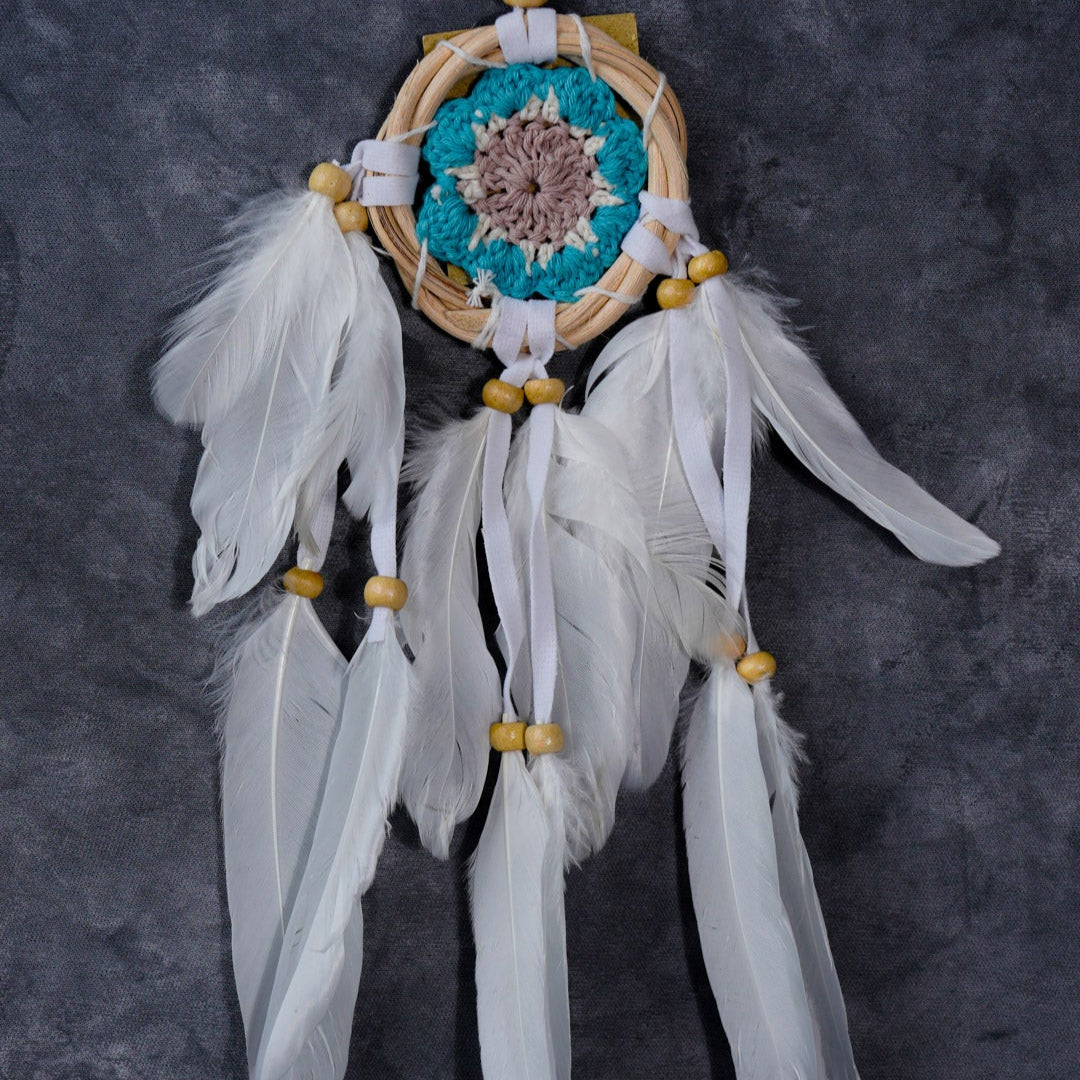 Hand-crocheted cotton mandala dream-catcher in rattan hoop with flowing white feathers and wood beads.