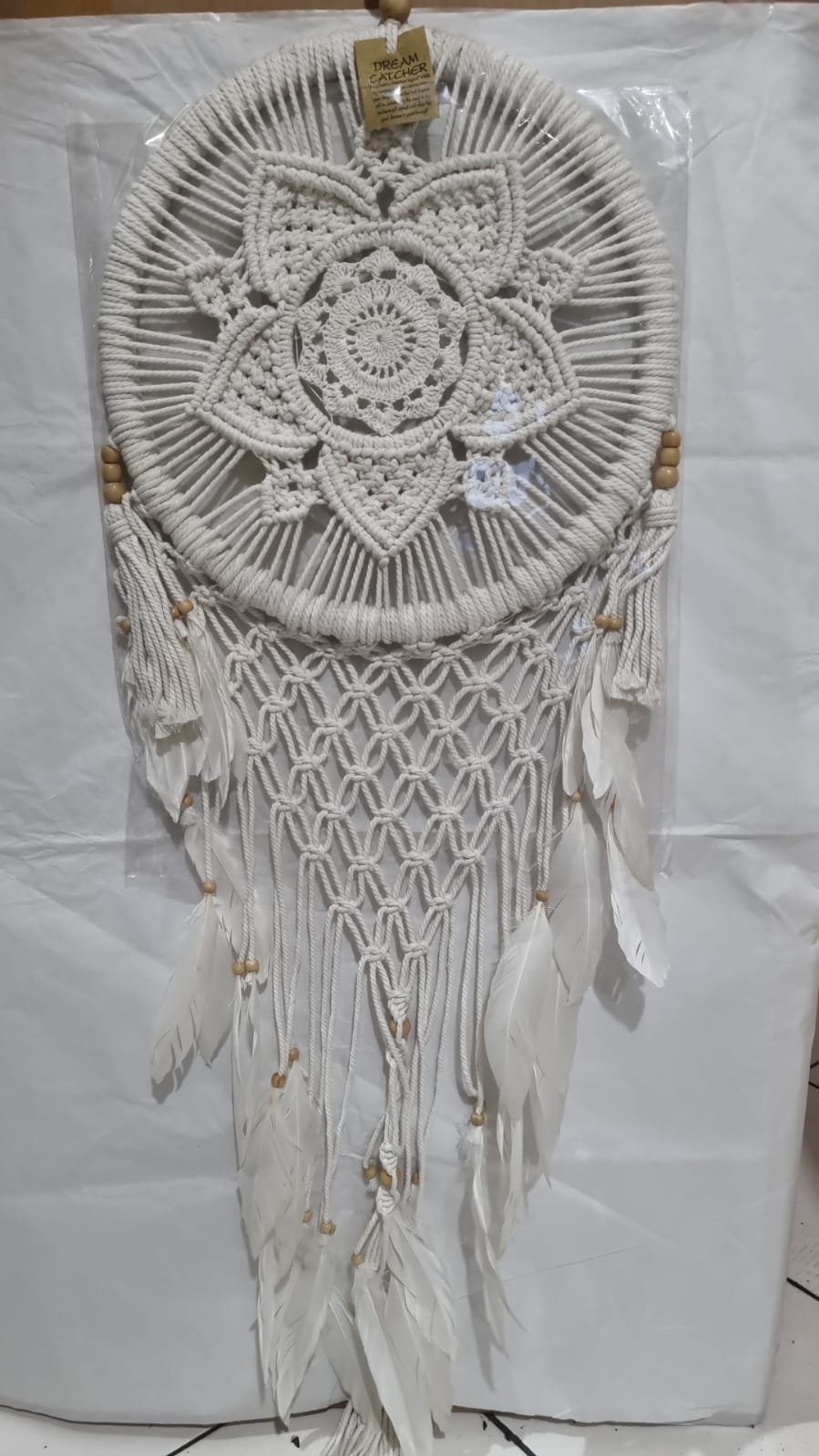 Bohemian macrame dreamcatcher with lotus flower mandala, featuring natural cotton rope, wood beads, and white feathers.