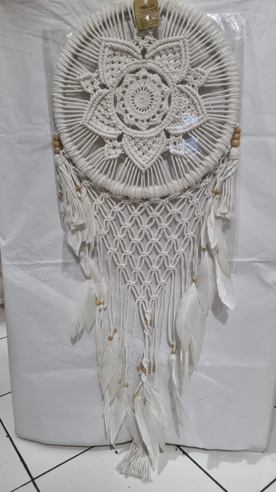 Bohemian macrame dreamcatcher with lotus flower mandala, featuring natural cotton rope, wood beads, and white feathers.