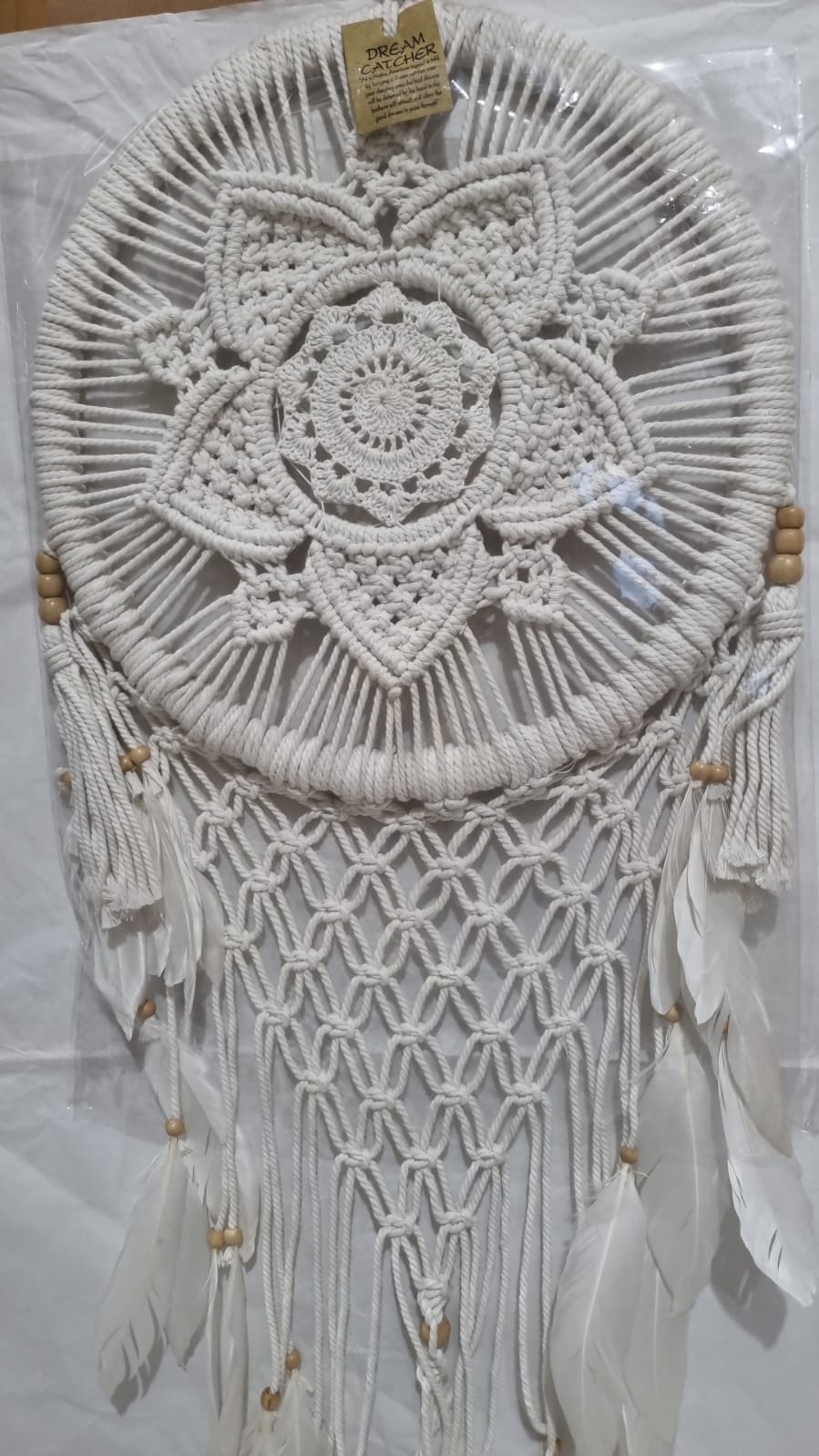 Bohemian macrame dreamcatcher with lotus flower mandala, featuring natural cotton rope, wood beads, and white feathers.