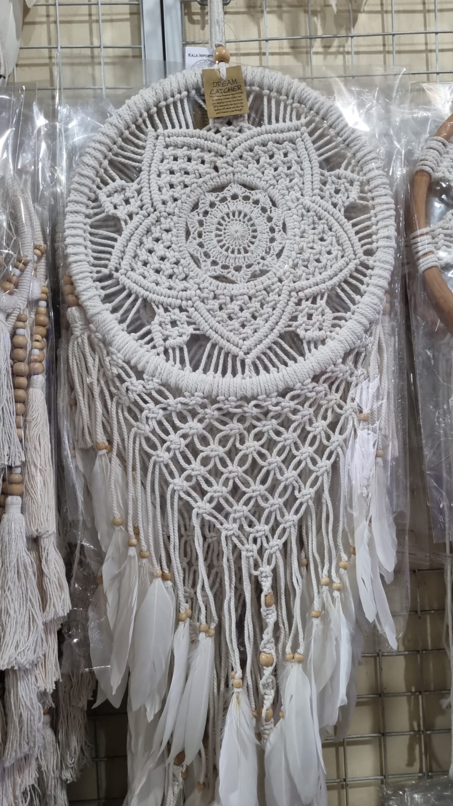 Bohemian macrame dreamcatcher with lotus flower mandala, featuring natural cotton rope, wood beads, and white feathers.