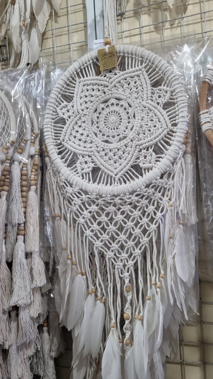 Bohemian macrame dreamcatcher with lotus flower mandala, featuring natural cotton rope, wood beads, and white feathers.