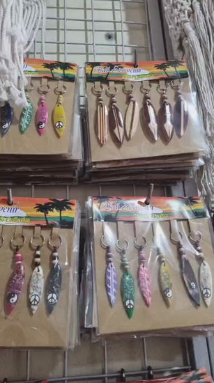 Resin surfboard keychain with shell accents, handmade souvenir keyring for bulk wholesale and surf shop gifts.