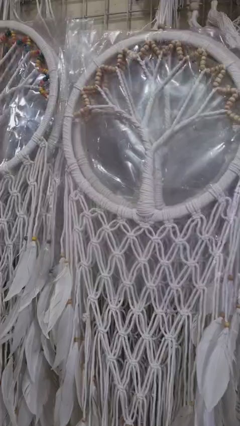 Macrame dreamcatcher in Tree of Life design, featuring wooden beads and white feathers, ideal for boho home decor or spiritual spaces.