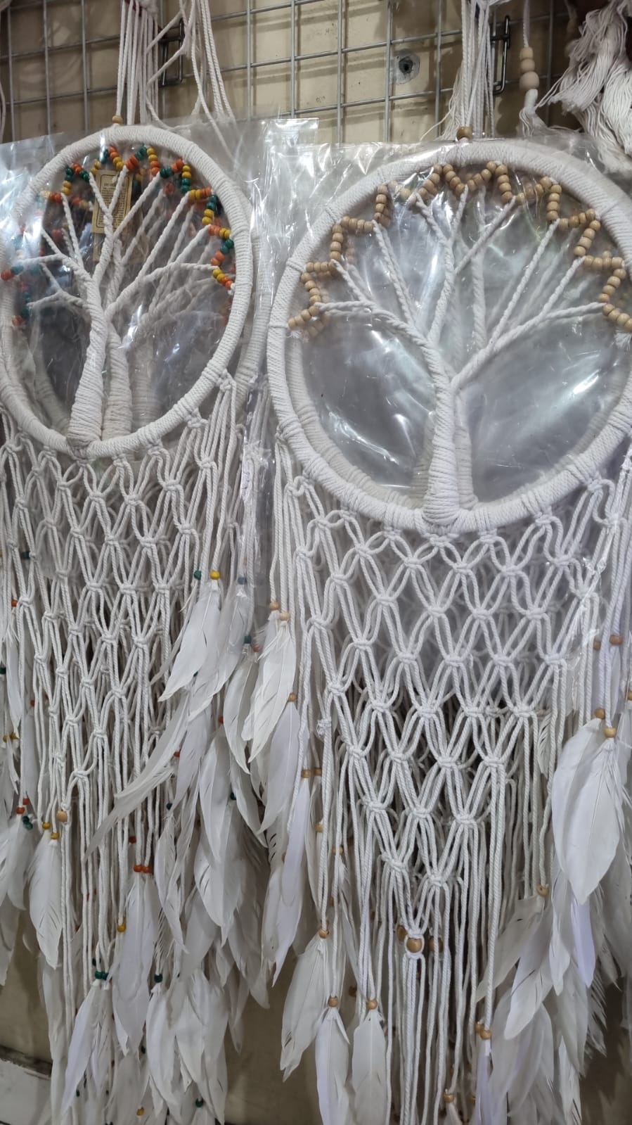 Macrame dreamcatcher in Tree of Life design, featuring wooden beads and white feathers, ideal for boho home decor or spiritual spaces.