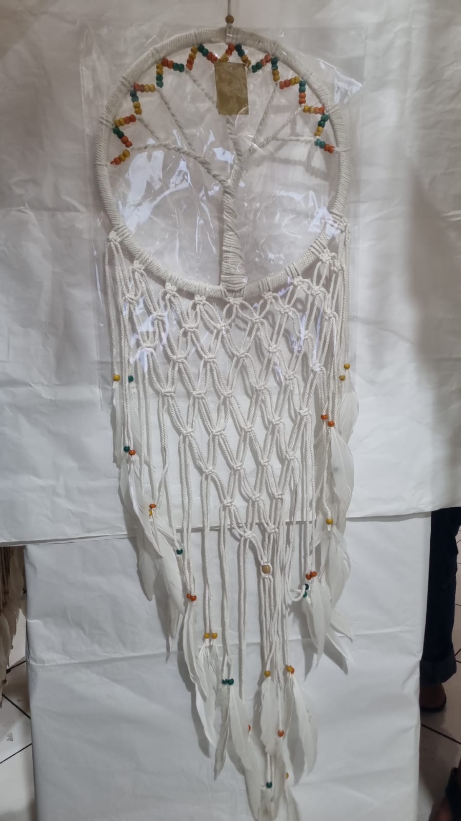 Macrame dreamcatcher in Tree of Life design, featuring wooden beads and white feathers, ideal for boho home decor or spiritual spaces.
