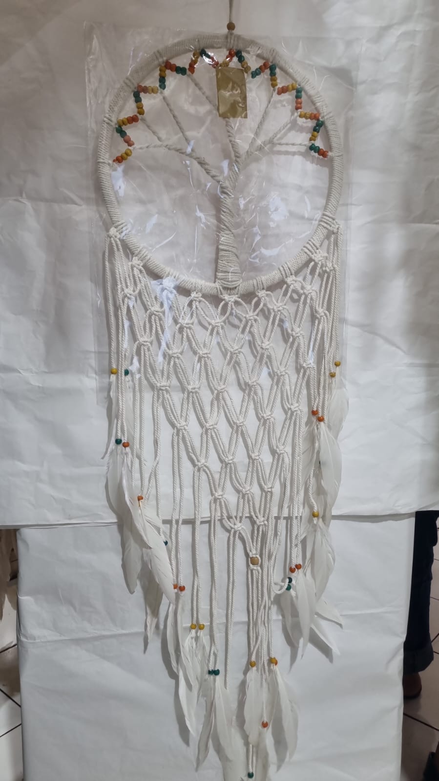 Macrame dreamcatcher in Tree of Life design, featuring wooden beads and white feathers, ideal for boho home decor or spiritual spaces.