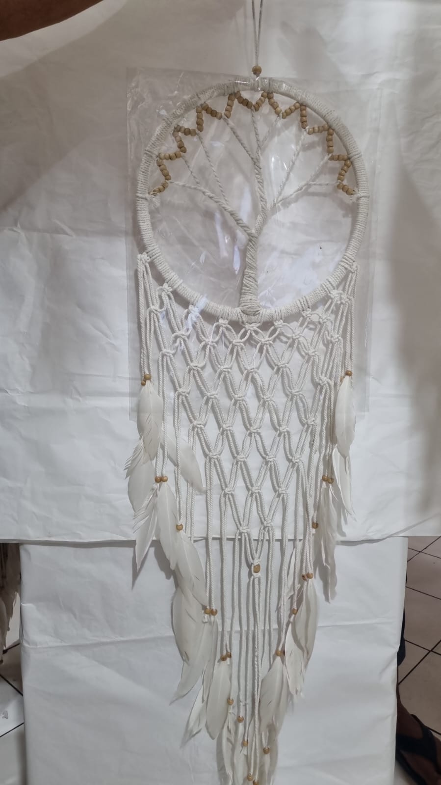 Macrame dreamcatcher in Tree of Life design, featuring wooden beads and white feathers, ideal for boho home decor or spiritual spaces.