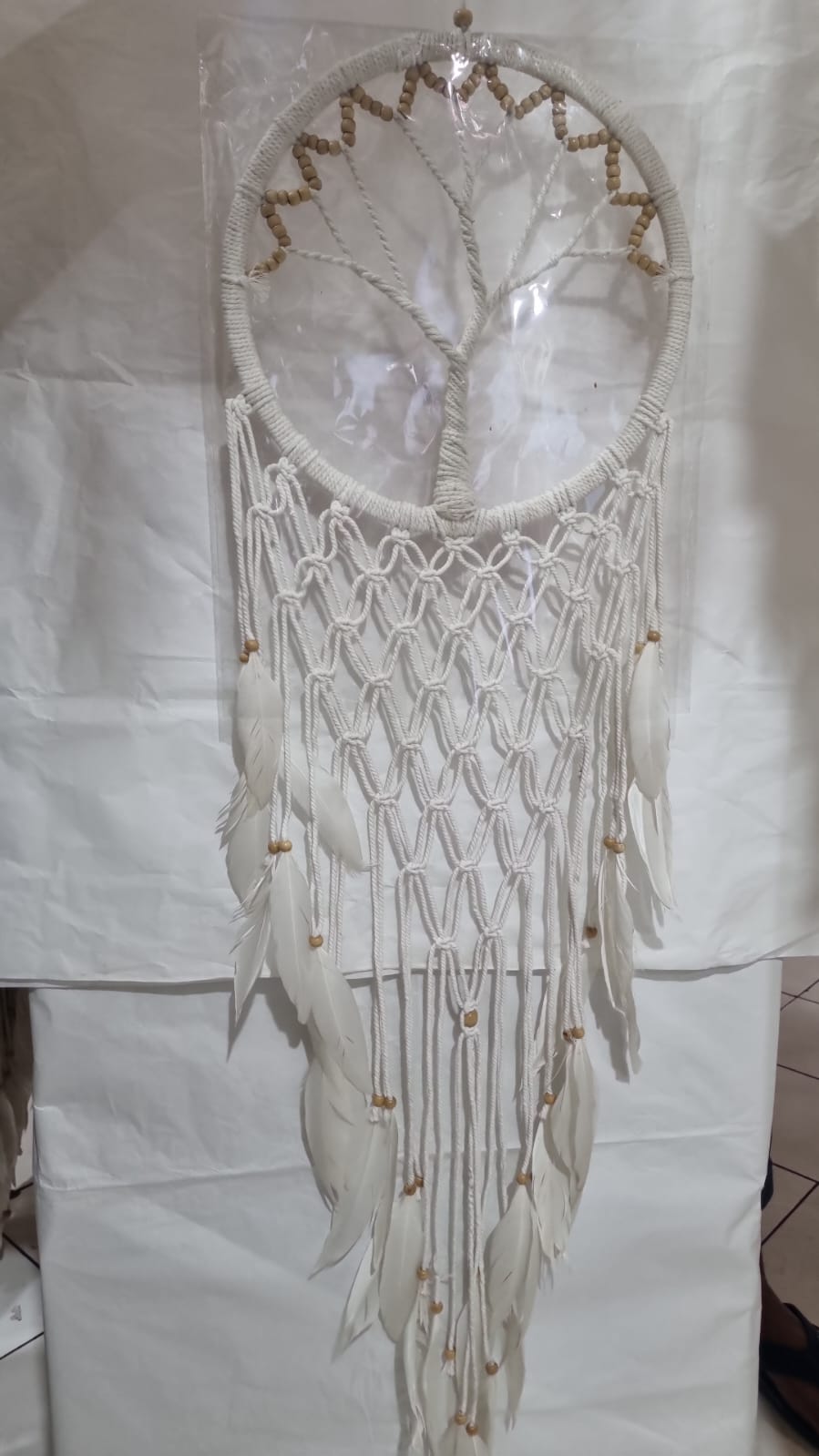 Macrame dreamcatcher in Tree of Life design, featuring wooden beads and white feathers, ideal for boho home decor or spiritual spaces.